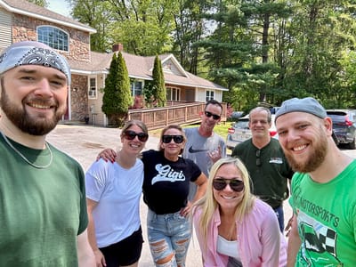 Group of staff and residents smiling outside the facility.