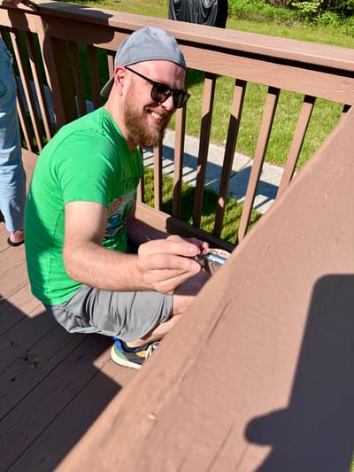Person painting a railing outdoors at the facility.