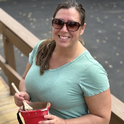 Woman smiling while painting outdoors.