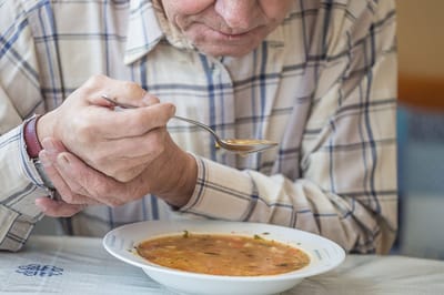 Senior man enjoying a bowl of soup.