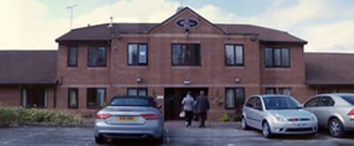 Exterior view of St Bartholomew's Court with residents entering