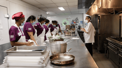 Kitchen staff preparing food in a facility kitchen