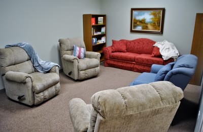 A cozy common area with recliners and a couch