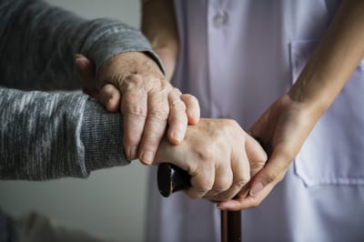 Caregiver holding hands with a resident