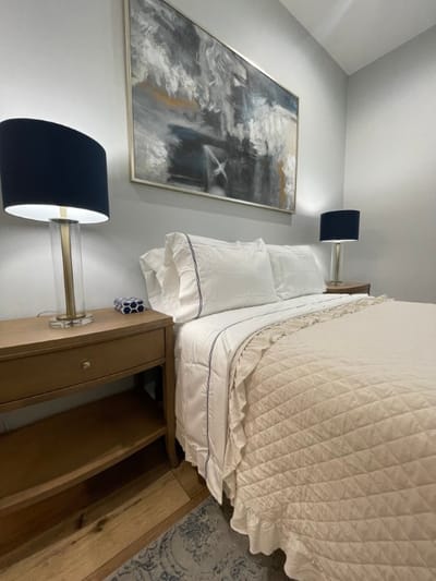 Cozy bedroom setting with artwork and bedside lamps