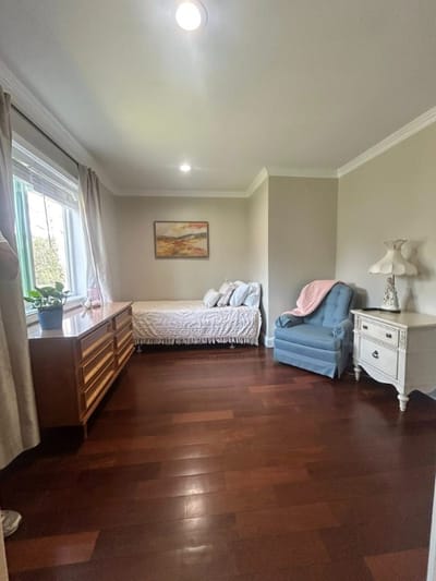 Bright resident room with wooden flooring and soft furnishings