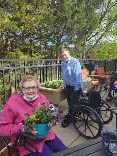 Residents gardening outdoors in wheelchairs