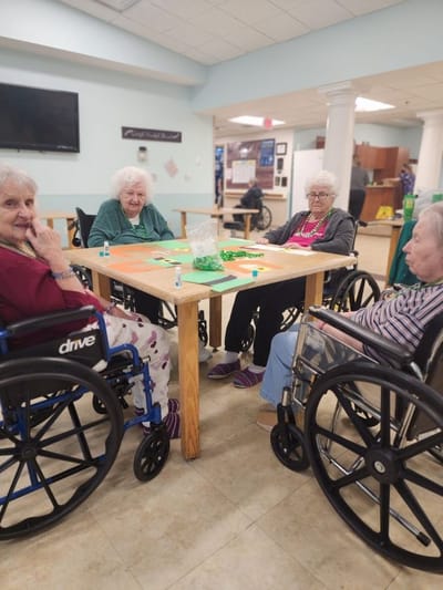 Residents engaging in a game at a common area table
