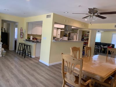 Interior view of a dining area with a wooden table and kitchen