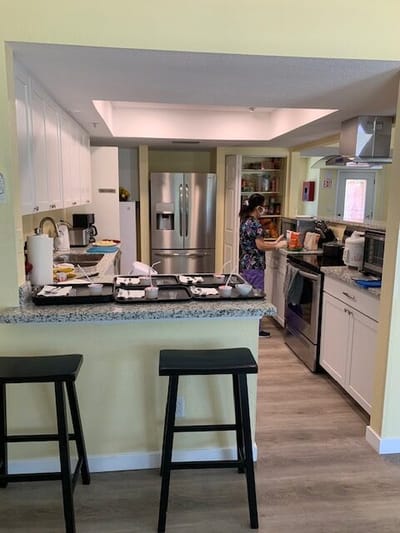 A staff member preparing food in a kitchen.