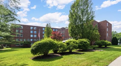 Exterior view of Bet Shalom Senior Apartments surrounded by greenery