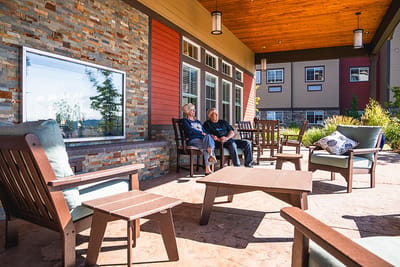 Two residents enjoying time on an outdoor patio