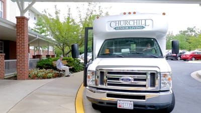 Facility shuttle parked outside with residents visible