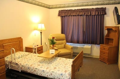 Cozy resident room with chair and floral bedding