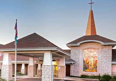 Exterior view of the facility entrance with a religious symbol