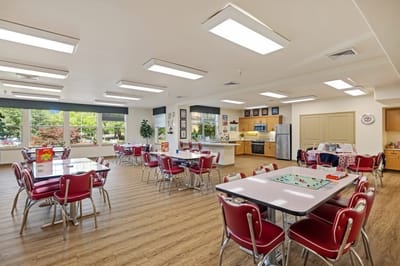 Bright dining room with tables and chairs set up