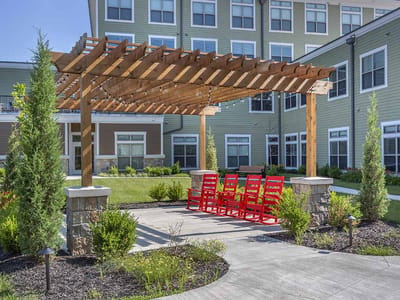 Outdoor space with a pergola and red rocking chairs
