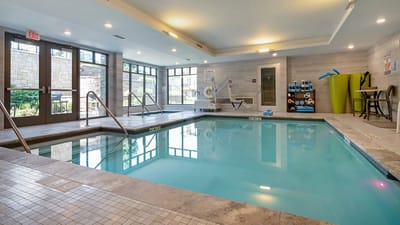 Indoor swimming pool area with sunlit windows