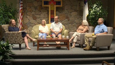 Residents and staff engaged in a discussion in a common area
