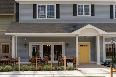Exterior view of a building entrance with patio furniture