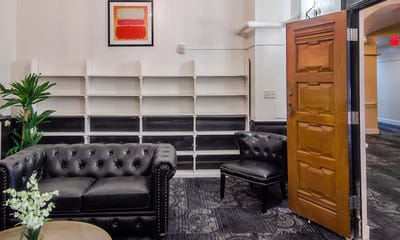 Cozy common area with a leather couch and door entry