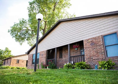 Exterior view of a brick building with landscaped yard