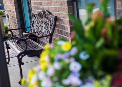 Outdoor bench with colorful flowers in the foreground.