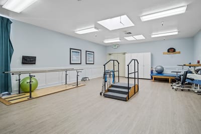 Physical therapy room with equipment and safety bars