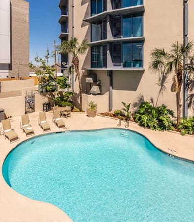 Outdoor pool area with sun loungers and tropical plants