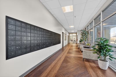 A well-lit interior hallway with mailboxes and seating