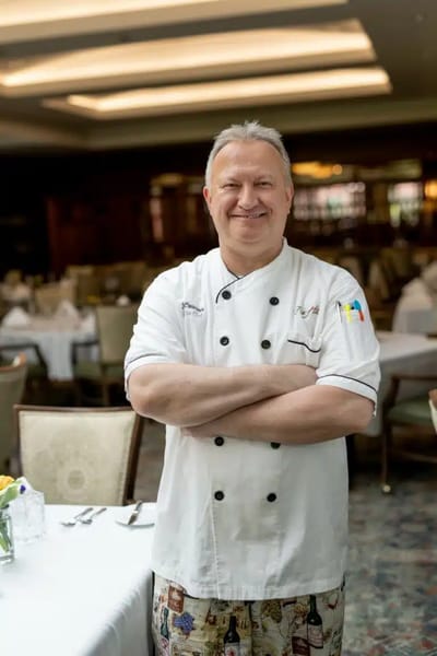 Chef in a dining room with set tables