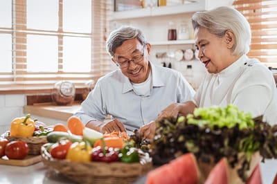 Seniors preparing food together in a kitchen