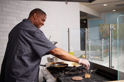 Chef grilling hamburgers in a kitchen area