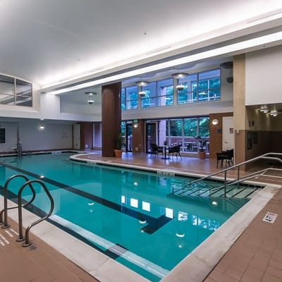 Indoor swimming pool with large windows and seating area
