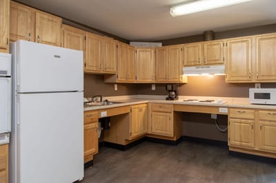 Bright kitchen area with wooden cabinets and appliances
