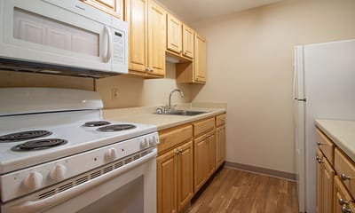 Bright kitchen area with wooden cabinets and appliances
