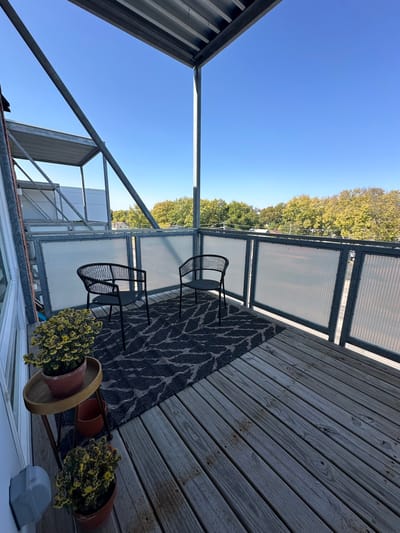Outdoor balcony seating area with plants
