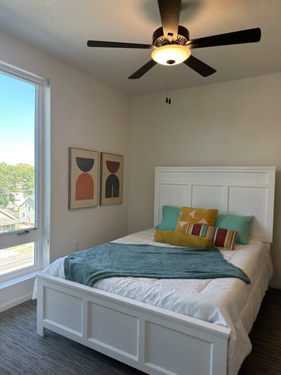 Brightly decorated private resident room with a bed and artwork