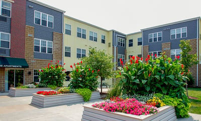 Exterior view of Prime Square Apartments with colorful flowers
