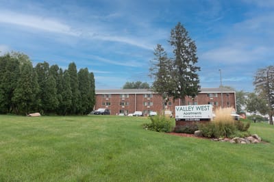 Exterior view of Valley West Apartments with green lawn