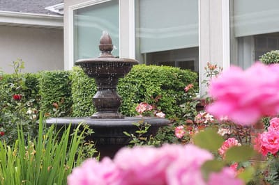 A charming outdoor fountain surrounded by flowers