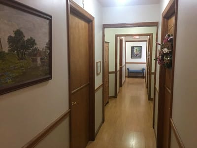 A hallway with doors and wall art in a senior living facility