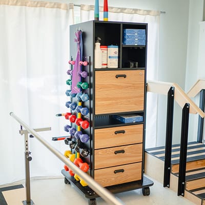 Rehabilitation cart with weights and supplies in therapy area