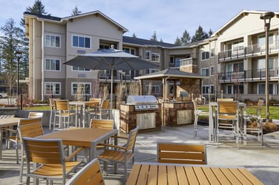 Outdoor grilling area with seating at a senior living facility