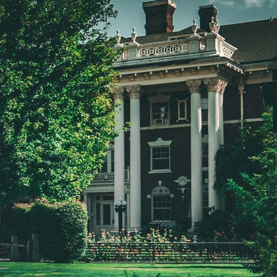 Exterior view of a historic building surrounded by greenery