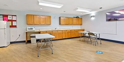 Bright common area with tables and kitchen amenities