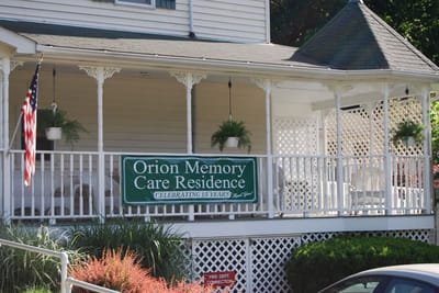Front porch of Orion Memory Care Residence with a celebration banner