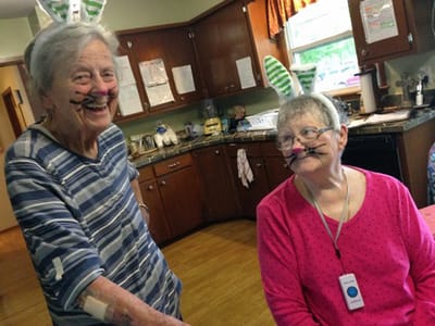 Two residents wearing bunny ear headbands and face paint.