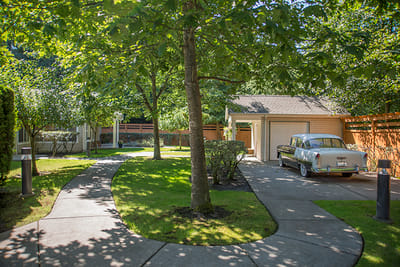 Scenic pathway with a vintage car and greenery.