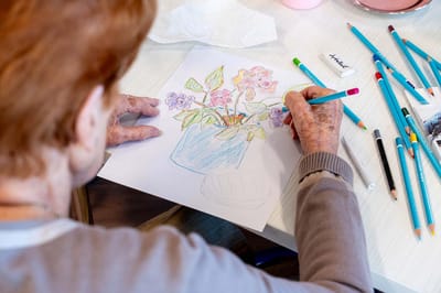 Resident coloring flowers with art supplies